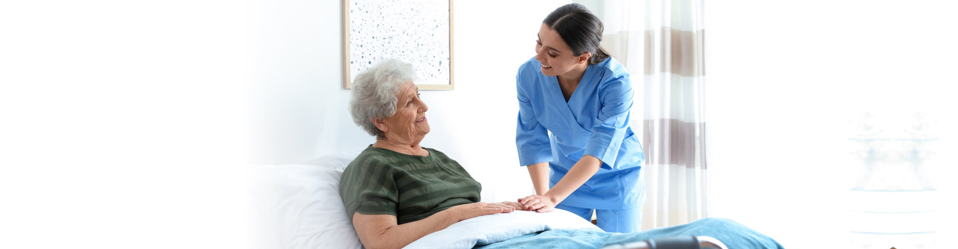 caretaker with senior woman in bed