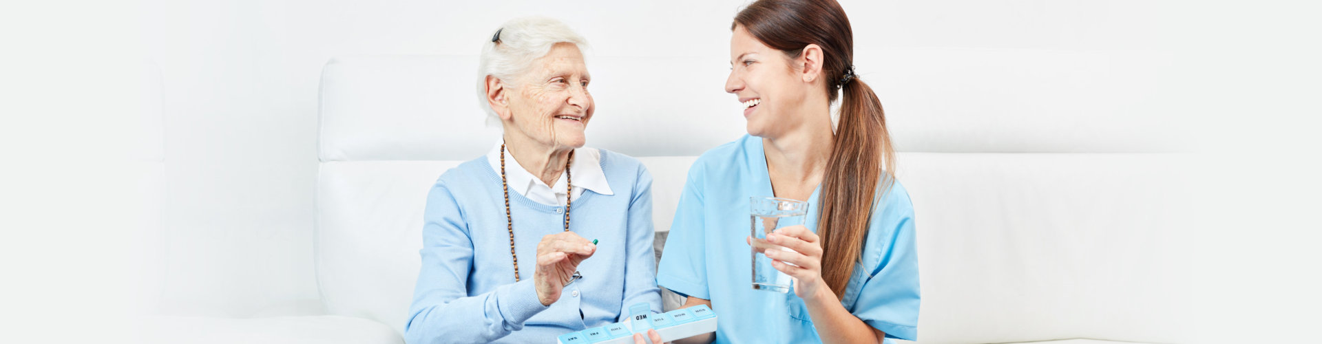 senior woman taking medication with caregivers